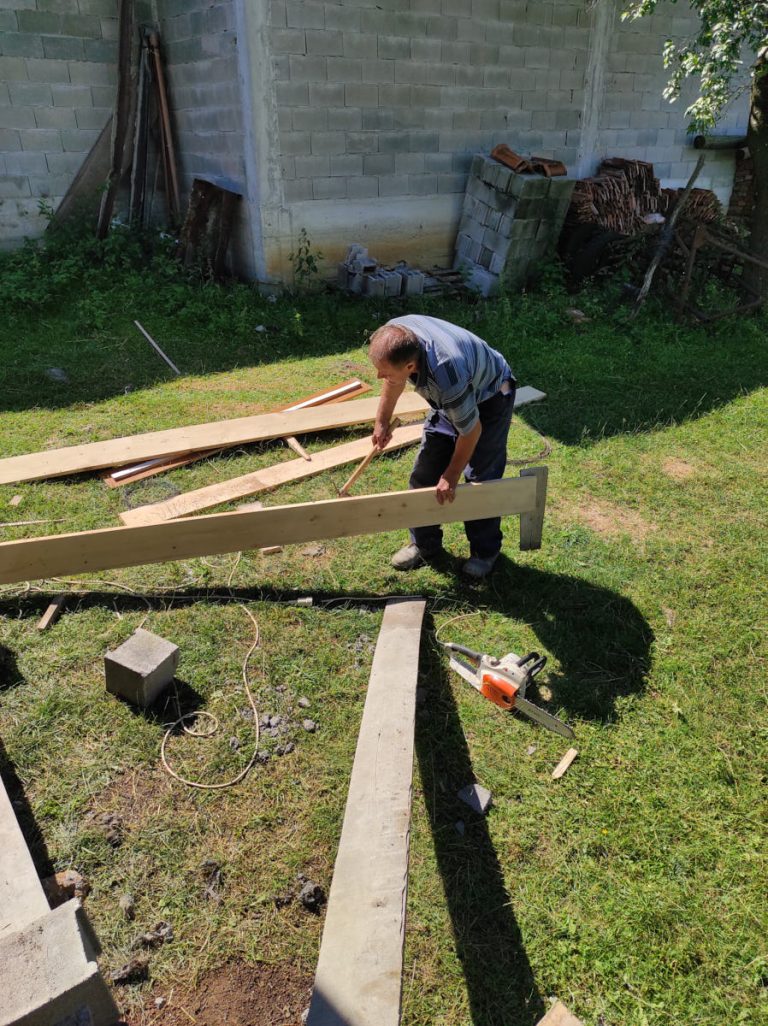 a worker trimming a wooden plank