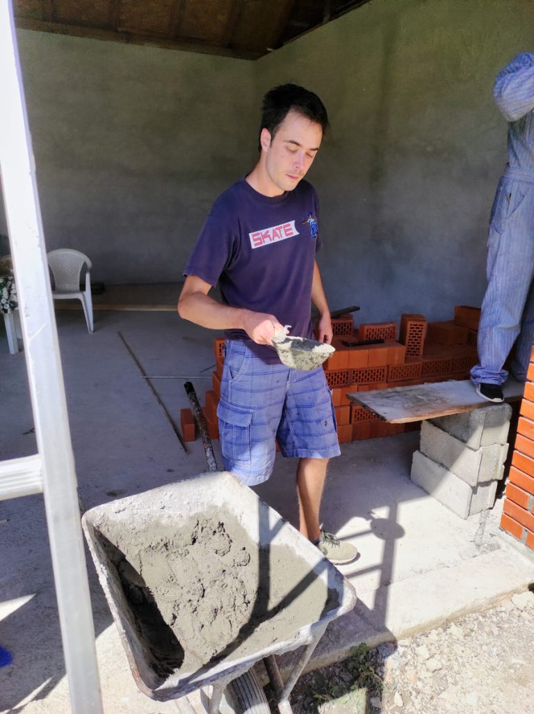 a worker with a pan full of concrete