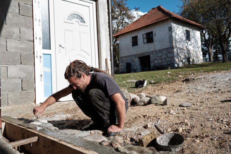 a worker building a cobblestone pavement