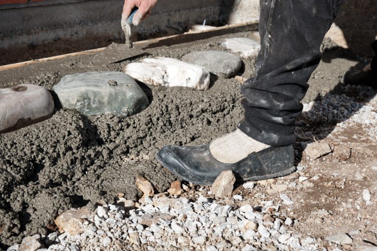 a worker building a cobblestone pavement