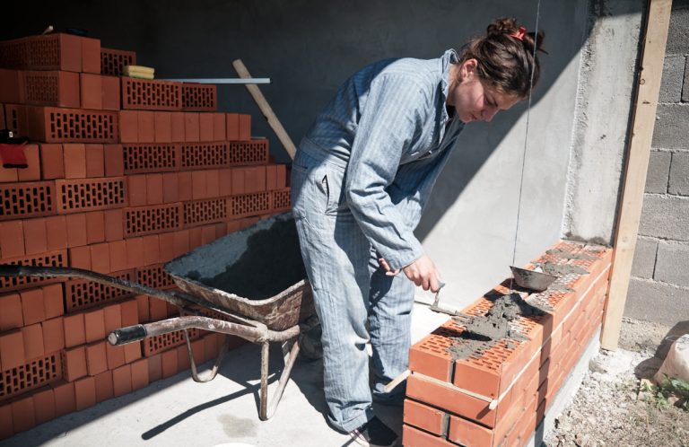 a worker building a brick wall