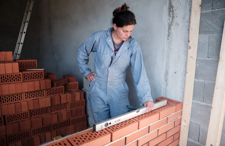 a worker building a brick wall