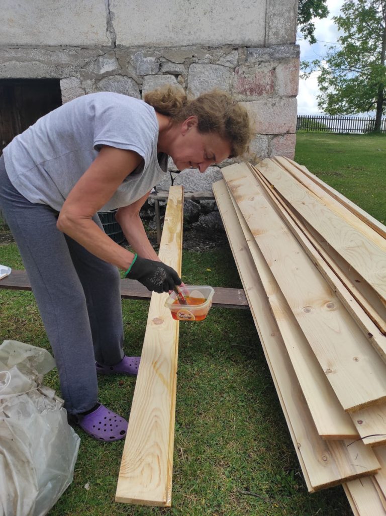 a worker staining wooden planks