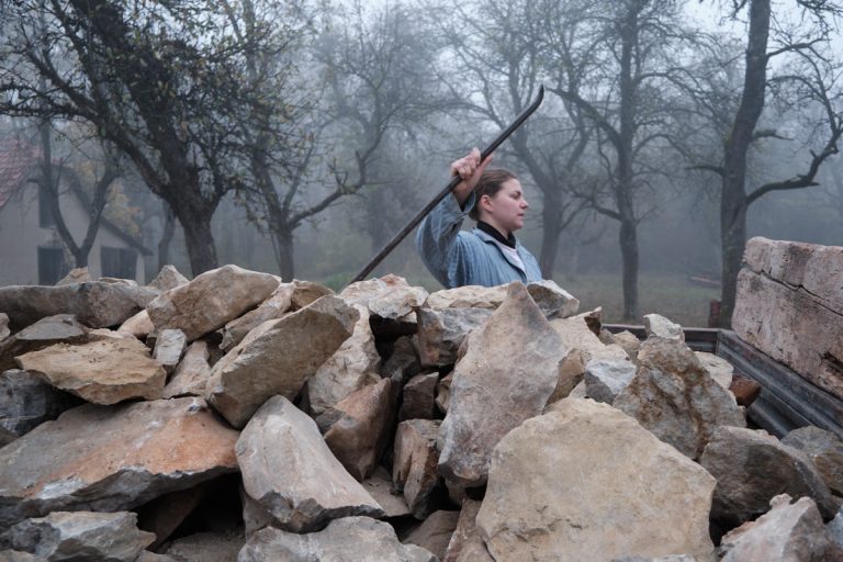 a woman next to a trailer full of rocks