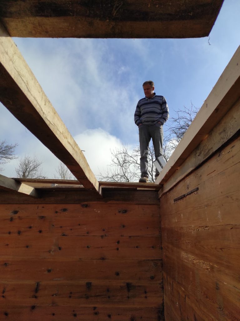 a man reviewing a wooden cottage