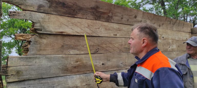 workers measuring old cottage logs