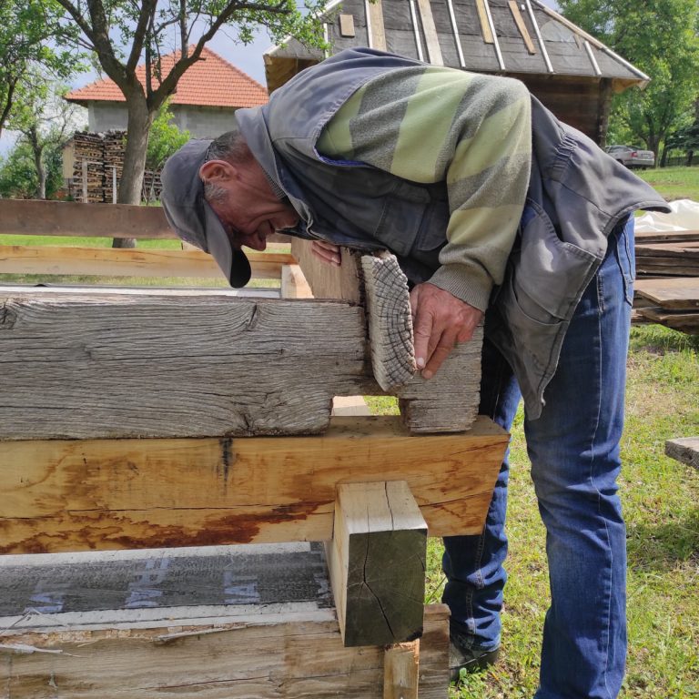 a worker joining an old cottage logs