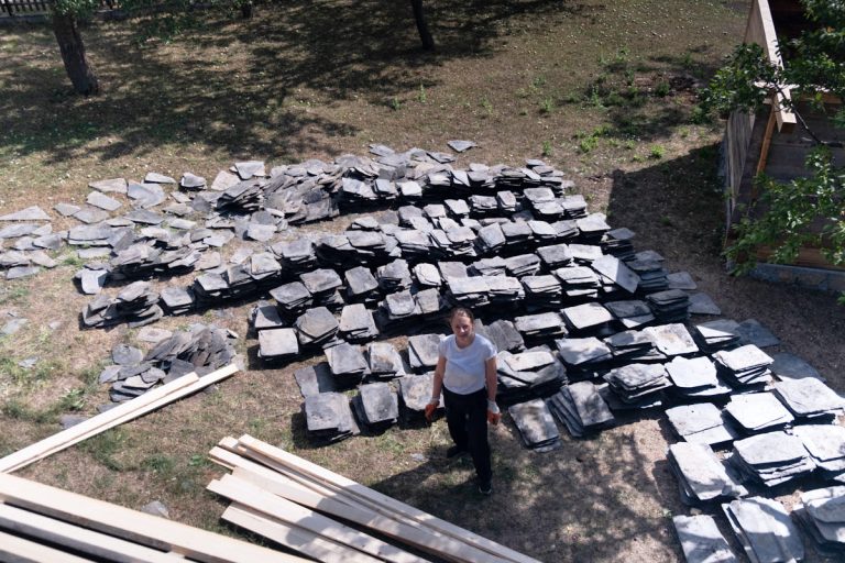 a woman posing by the pile of slate