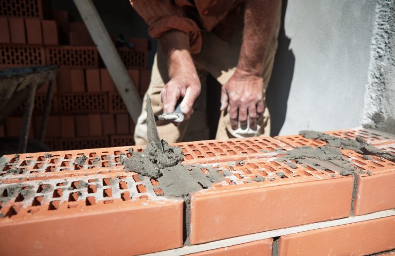 a worker building a brick wall