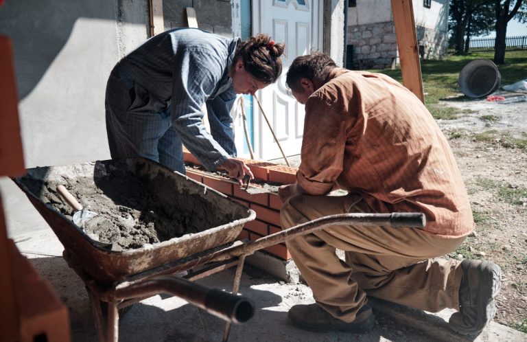 a worker building a brick wall