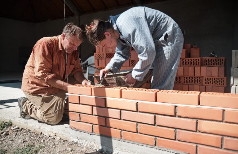 a worker building a brick wall