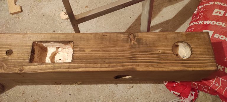 a wooden beam with holes for electric switches