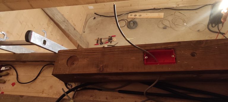 a wooden beam with holes for electric switches
