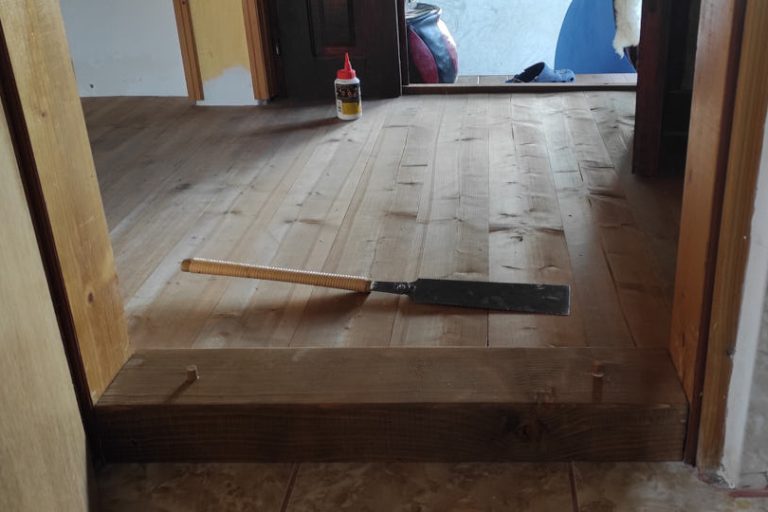 an installed doorstep with wooden dowels and a ryoba saw