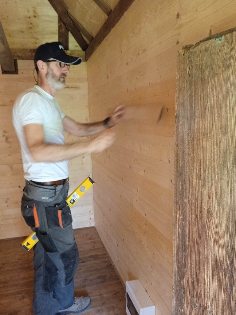 a worker with a level in a wooden cottage
