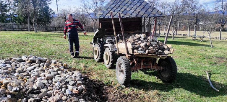 a man ignite a compact traktor loaded with rocks