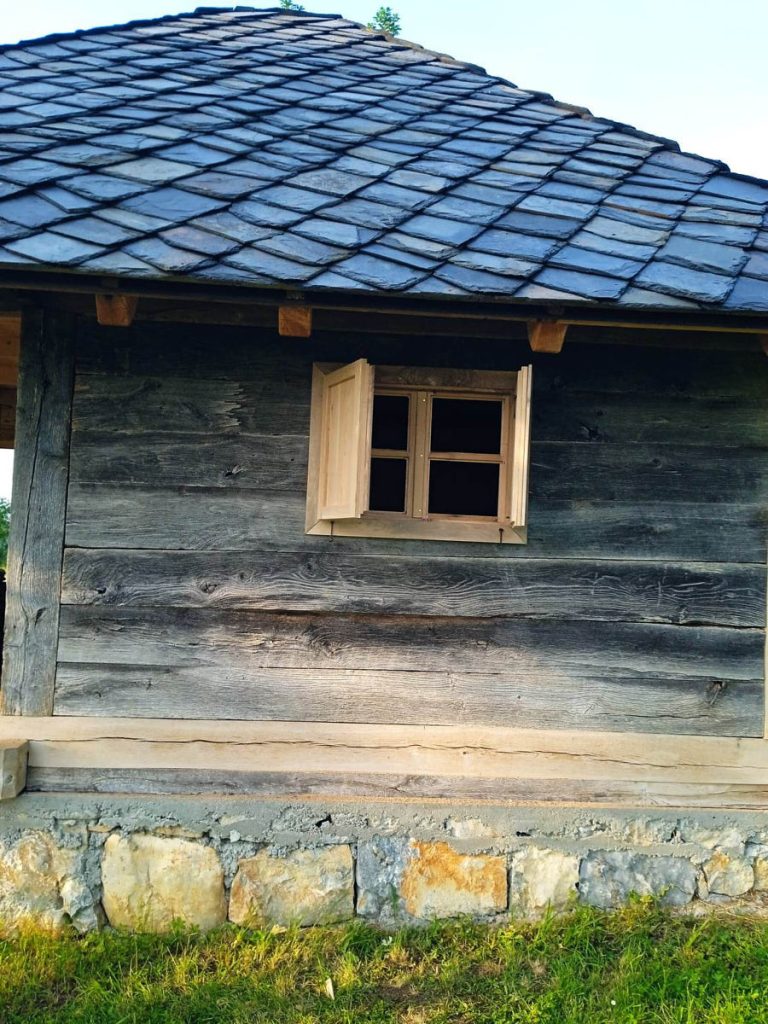a wooden cottage with a stone roof
