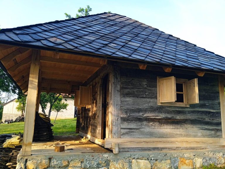 a wooden cottage with a stone roof