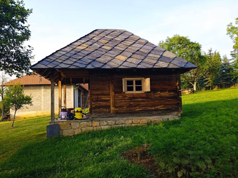 a wooden cottage with a stone roof