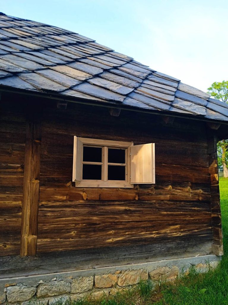 a wooden cottage with a stone roof