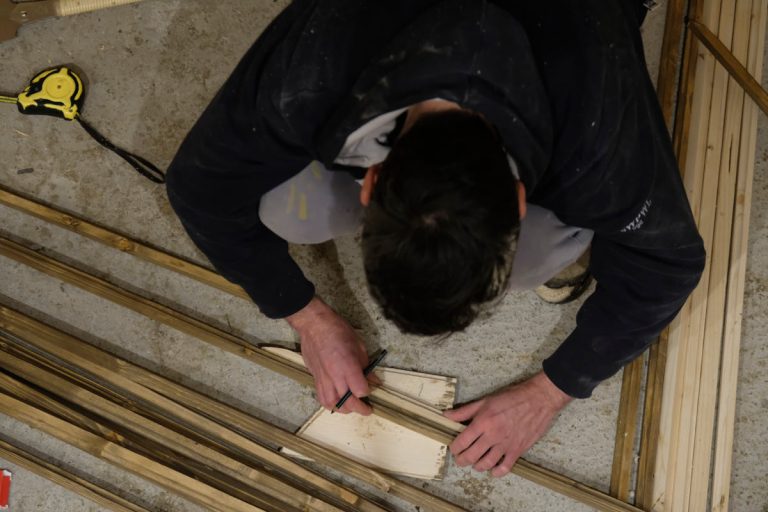 a man marking wooden sticks