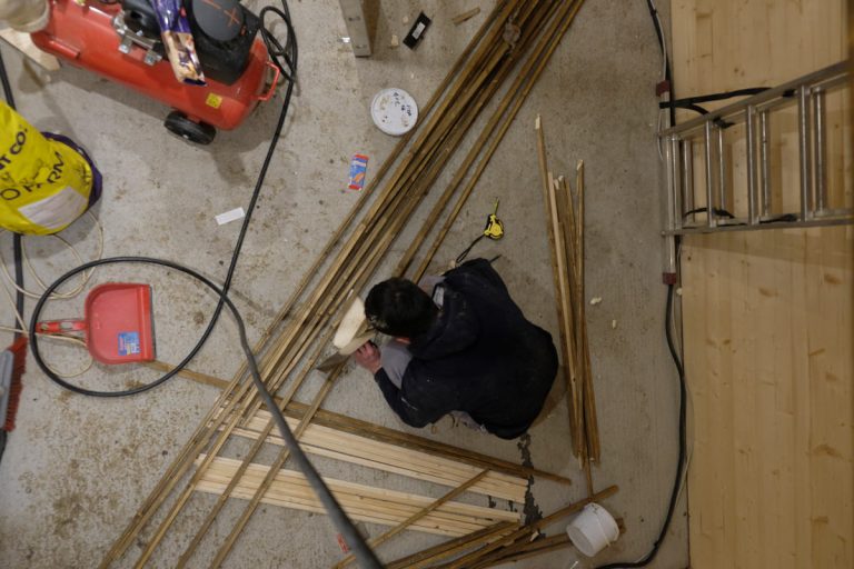 a man sawing wooden sticks