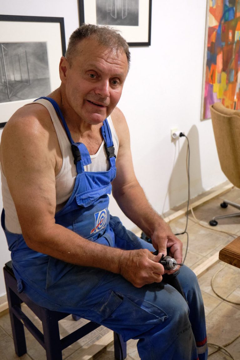 a worker tightening up a drilling bit into a drilling machine