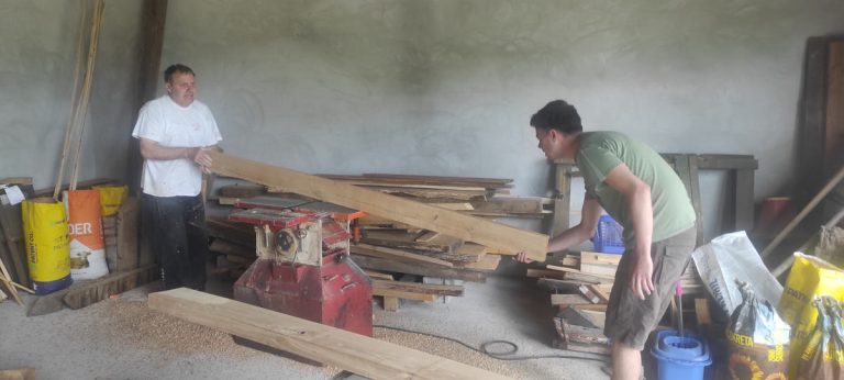 men plaining a wooden plank