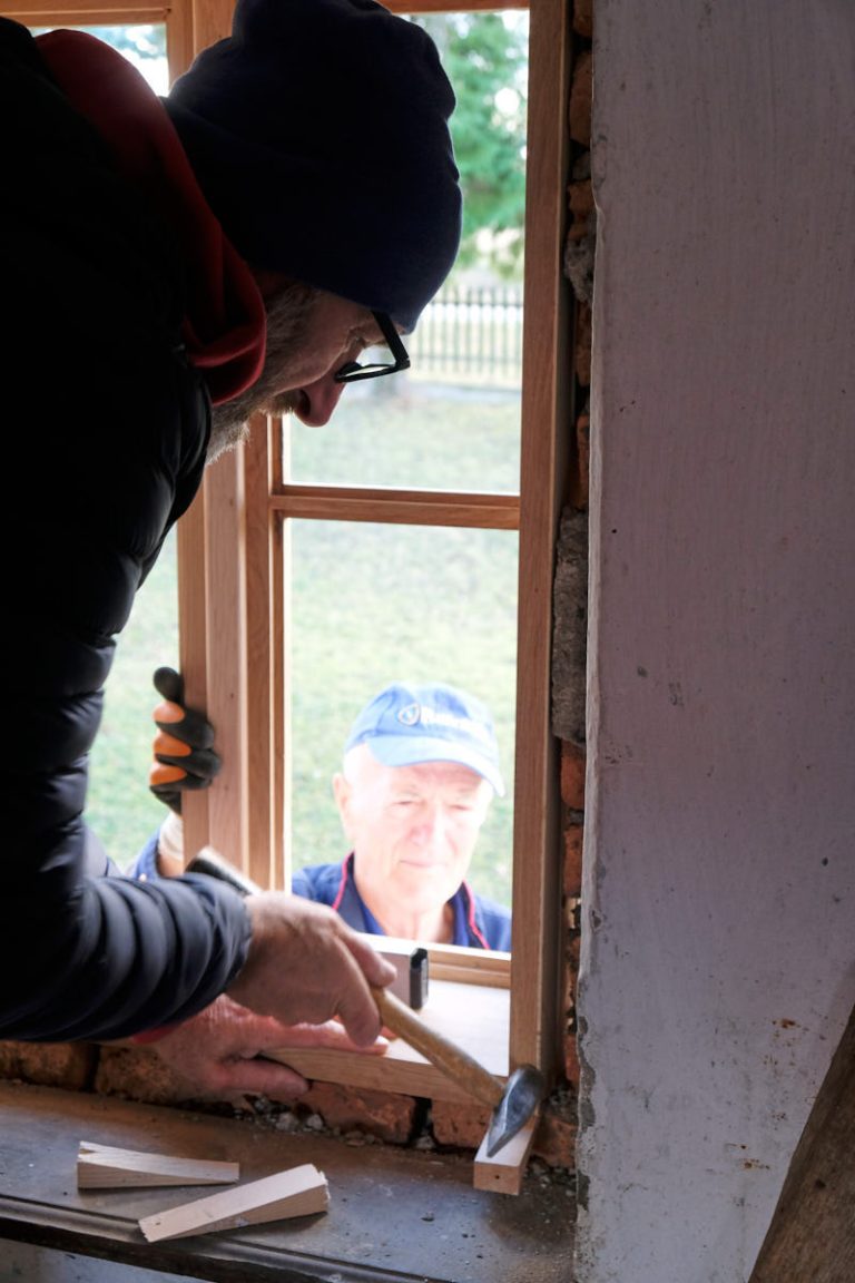 workers install wooden windows