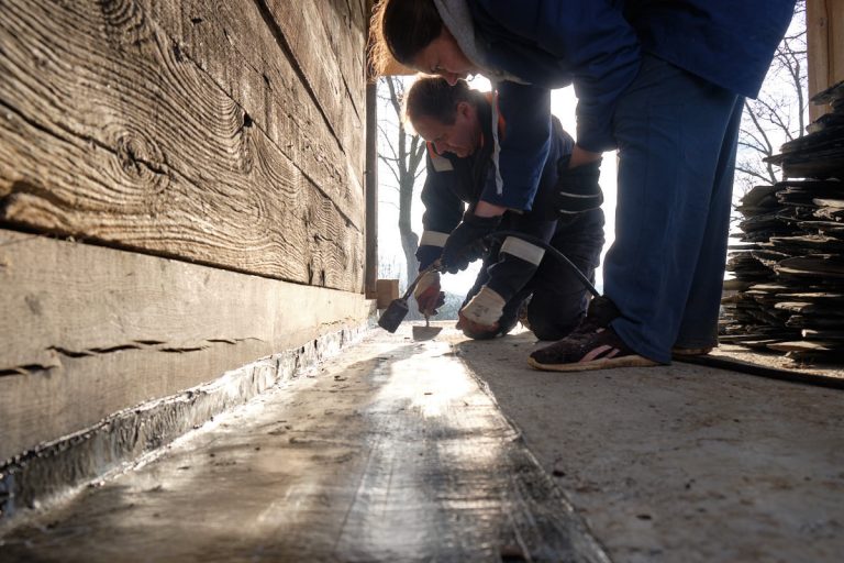 workers gluing bitumen on a porch