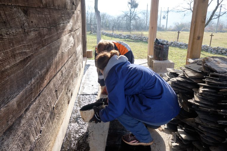 workers gluing bitumen on a porch