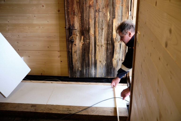 a man measuring floor planks distance