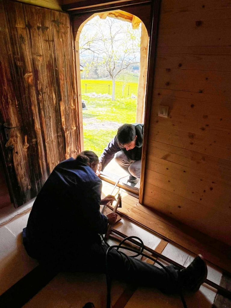 a man and a woman working on a wooden cottage floor