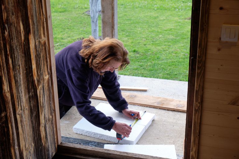 a woman measuring a styrofoam board