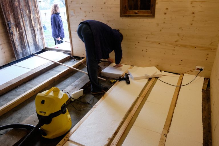 a woman placing styrofoam boards on a floor
