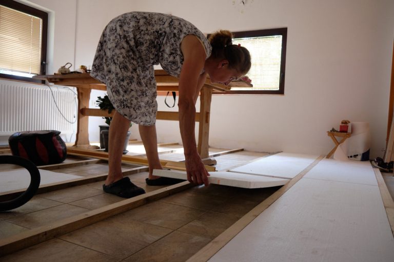 a woman placing styrofoam boards between planks