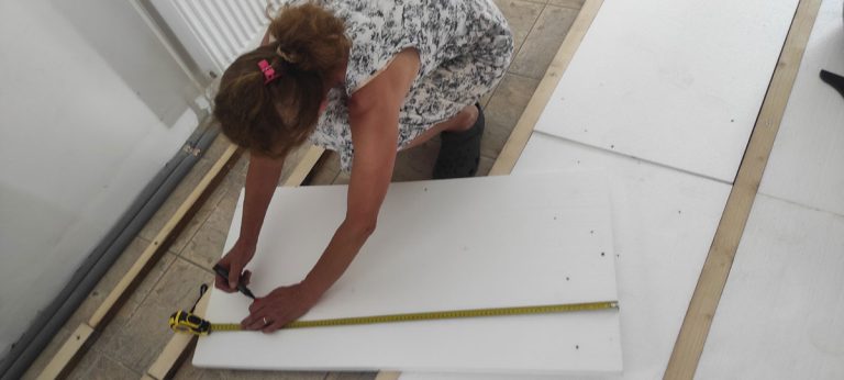 a woman measuring a styrofoam board