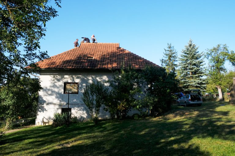workers on a roof installing a chimney