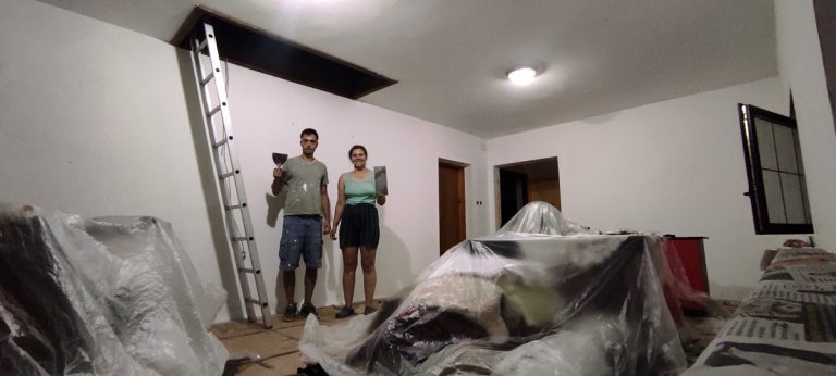 a boy and a girl posing with painting equipment in a room