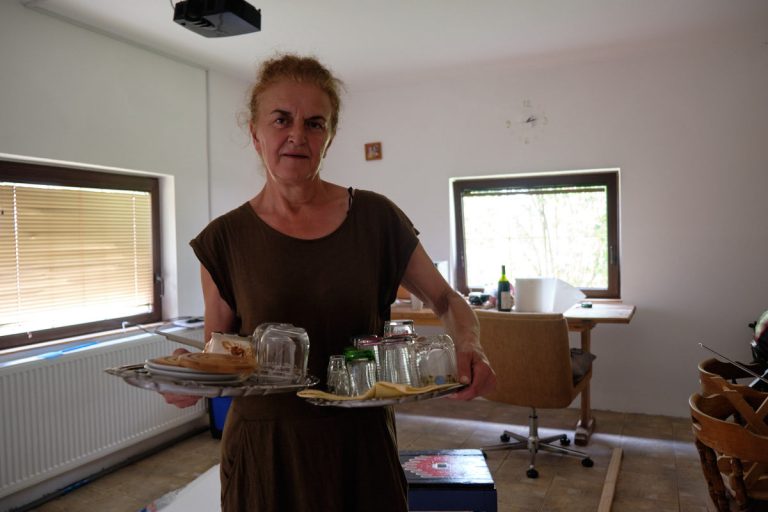 a woman holding plates with glasses and dishes