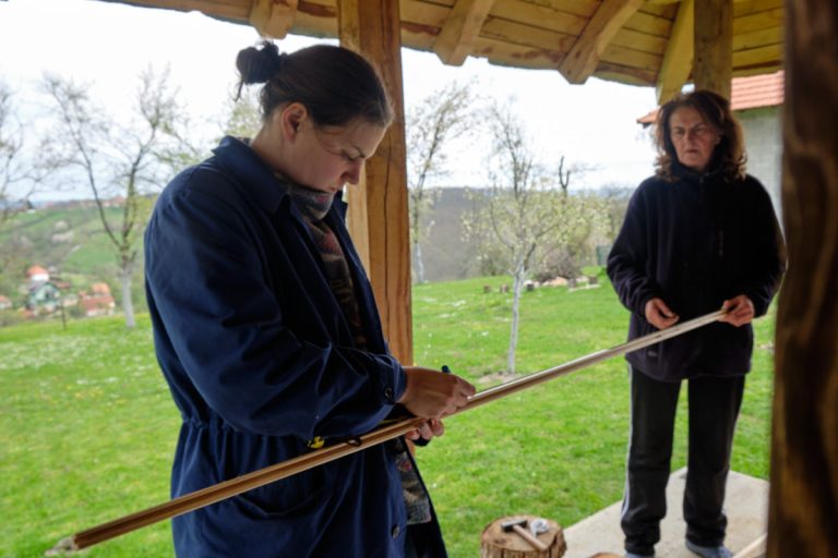 women marking a wooden slat