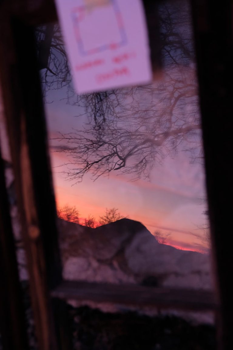 a reflection of a sunset in a window glass