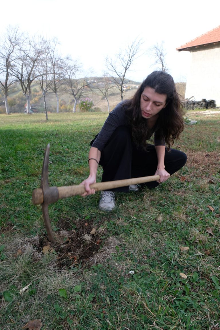 a girl digging a hole with a pickaxe