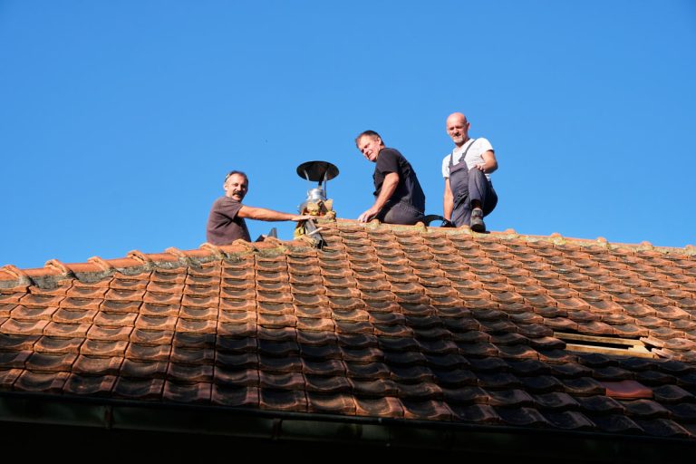 workers on a roof installing a chimney