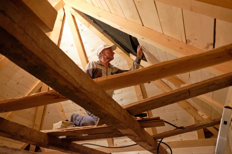 a worker building an interior of an old wooden cottage