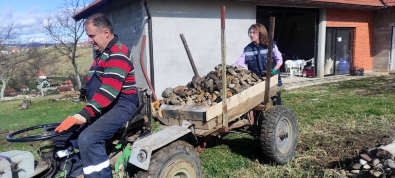 a man and a woman loading stones in a carriage