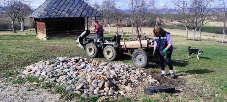 a man and a woman loading stones in a carriage