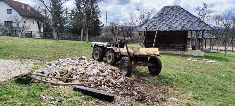 a stone pile by a compact tractor