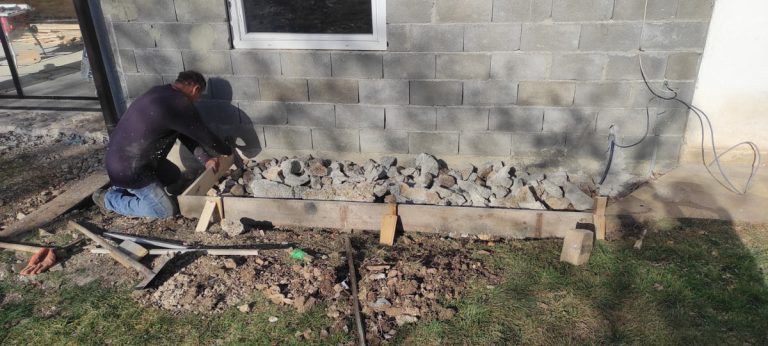 a worker building a cobblestone pavement