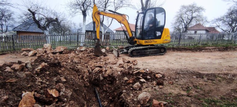 a man digging a water channel wiht an excavator